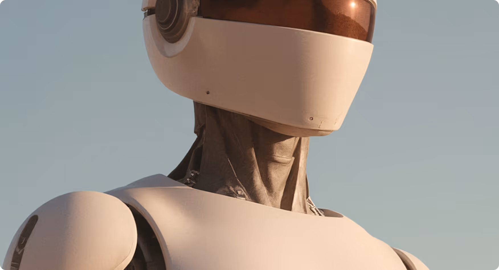 Close-up of a humanoid robot with a smooth white helmet-like head and a metallic neck and shoulders against a clear sky.